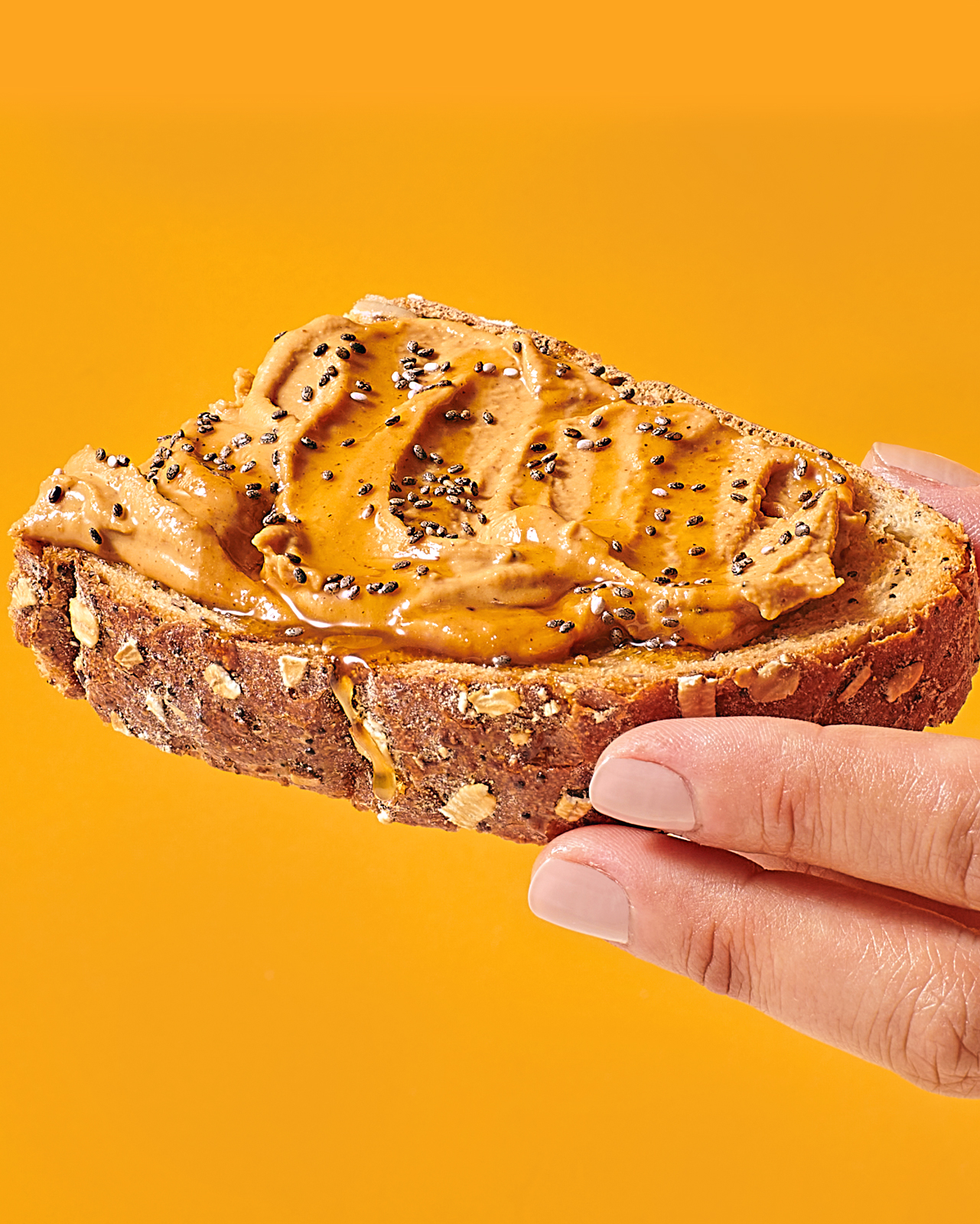 Hand holding toast TruNut powdered peanut butter product photography.